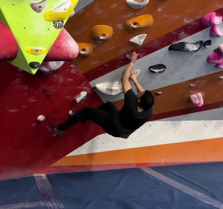 Amirali climbing an indoor bouldering wall